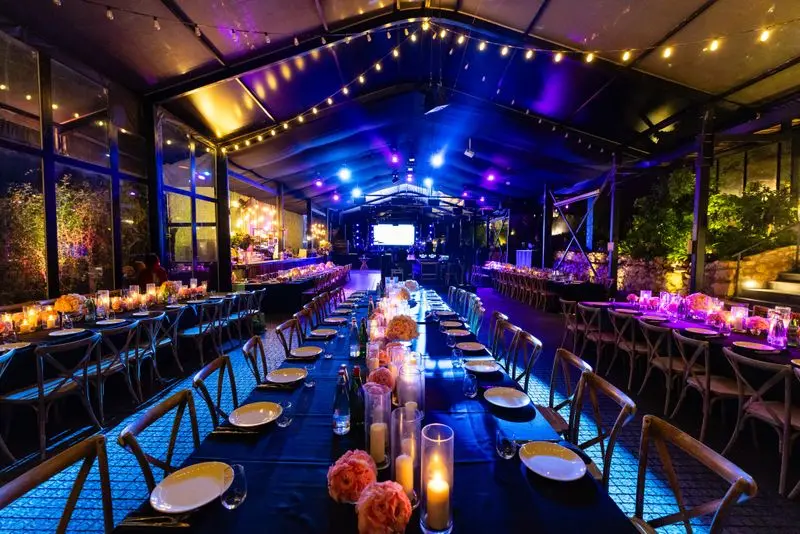 Chic indoor event venue with elegant decor, ambient lights, and beautifully set tables.